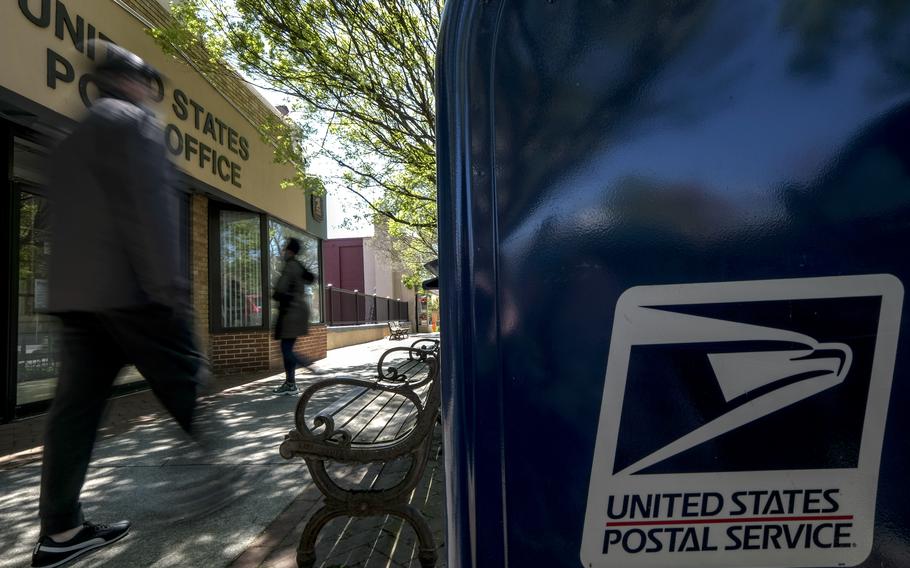 Pedestrians outside the post office in Takoma Park, Md., in 2020. The Postal Service is struggling financially and considering slowing delivery to some areas. 