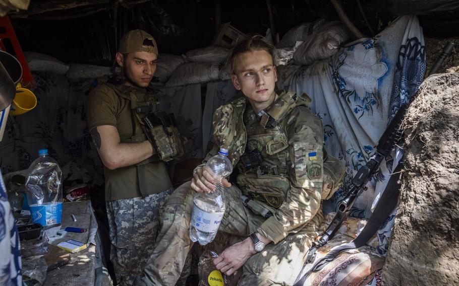 Soldiers with the call signs Witcher, 19, right, and Honey, left, from Ukraine’s 78th Assault Regiment rest after an early start in a trench position, forward from the village of Mala Tokmachka in Zaporizhzhia, Ukraine.