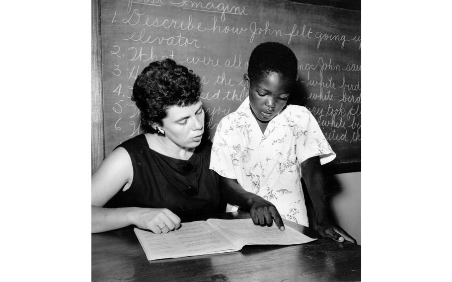 Donna Frede helping fourth-grader Norman Ross with a task