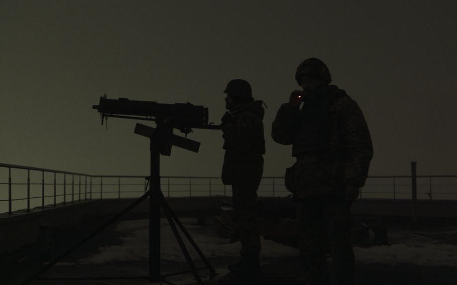 Mriya volunteers with a machine gun on a rooftop. MUST CREDIT: Sasha Maslov for The Washington Post