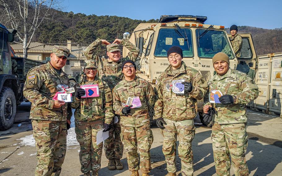 American soldiers pose with their Valentine’s Day cards.