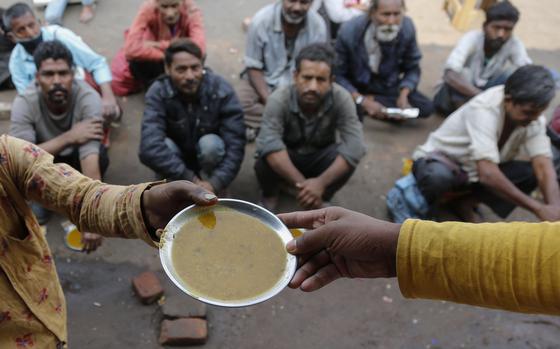 people-wait-for-free-food-outside-an-eatery-in-ahmedabad-india-on-jan