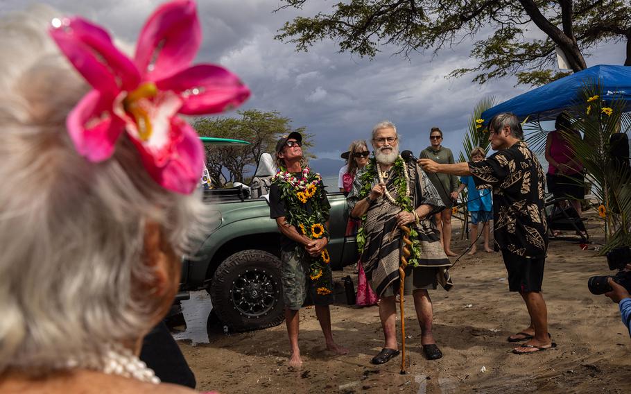 Kahu Sam Ka'ai says a blessing in honor of Carole Hartley while standing beside her longtime partner, Charles Paxton, left, at Ukumehame Beach near Lahaina during a celebration of Auntie Carole's life on what would have been her 61st birthday. 