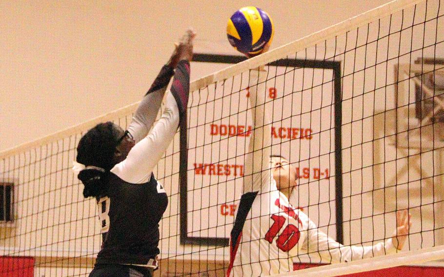 Zama's Elon Broomes and Nile C. Kinnick's Kay Kim battle for the ball at the net during Monday's DODEA-Japan/Kanto Plain volleyball match. The Red Devils won in two sets.