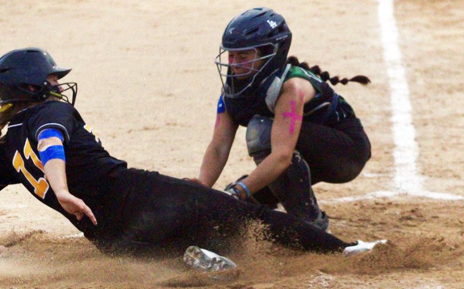 Kadena's Emaleigh Appleton gets tagged out by Kubasaki catcher Taylor Tobin during Wednesday's championship game in the Division I softball tournament. The Panthers repeated their title, beating the Dragons 10-5.
