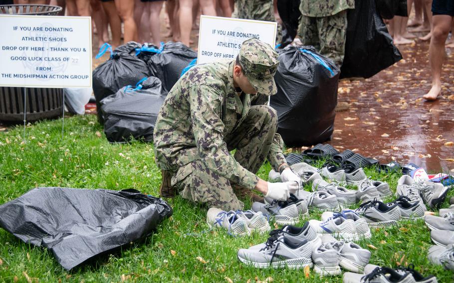 U.S. Naval Academy Midshipmen Action Group (MAG) collect shoes from the fourth class (freshman) to give to shelters in Washington, D.C., before they climb Herndon monument. The class of 2027 completed the climb in 2 hours, 19 minutes and 11 seconds.