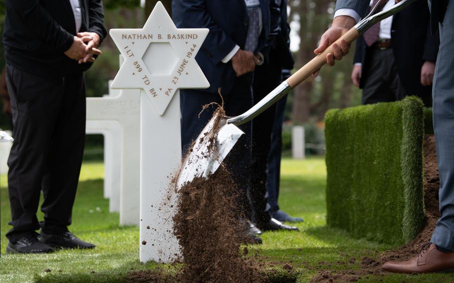 Dirt is shoveled into the grave of Army 1st Lt. Nathan Baskind, who was buried at Normandy American Cemetery in France on June 23, 2024, exactly 80 years after his death in World War II. 