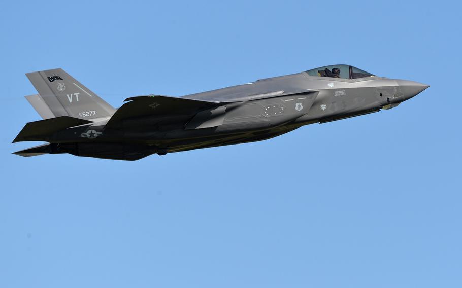 A fighter jet flies through a blue sky after taking off from a U.S. Air Force base in Europe.