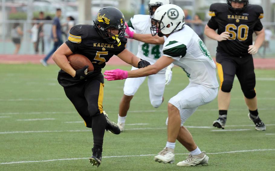 Kadena running back Ethan Ferch tries to avoid Kubasaki defender Connor McBee.