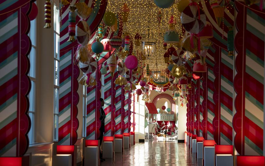 Enormous candies and treats dangle from the ceiling of the White House’s East Colonnade, buttressed by candy cane columns. 