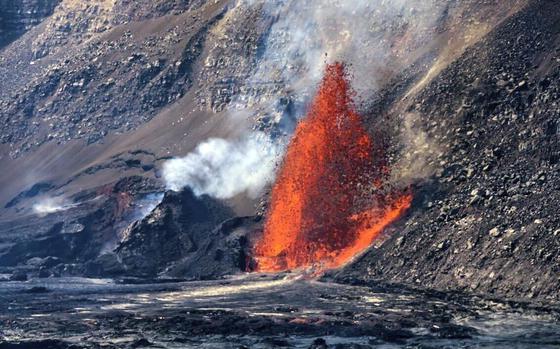 A red fountain of lava shoots up from a fissure in the side of a volcano.