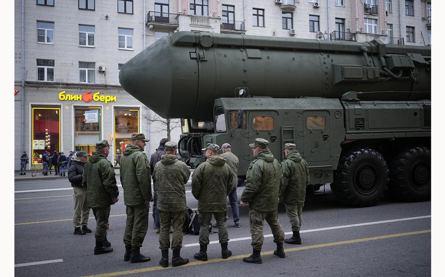 Soldiers stand next to a Russian RS-24 Yars ballistic missile.