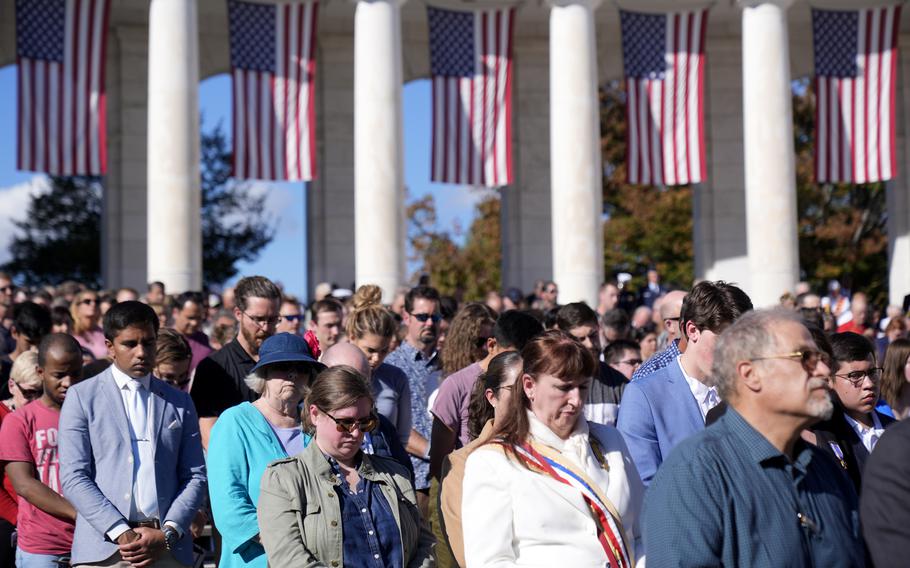 Attendees bow their heads as President Joe Biden speaks