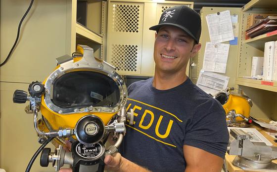 Navy diver Mark Desmarais holds the type of helmet used on the Heaven ...