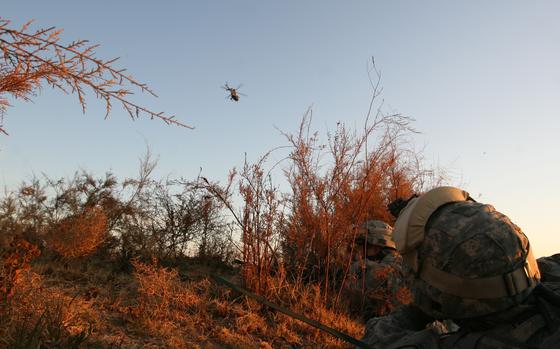 Pir Ahmad , Iraq, Dec. 12, 2007: First Lt. Jordan Pagones, 23, of Fishkill, N.Y., looks up from his ambush position as an OH-58 Kiowa scout helicopter arcs overhead during an operation in the village of Pir Ahmad, in northern Iraq. Pagones is the fire support officer for Troop C, 1st Squadron, 71st Cavalry Regiment, 10th Mountain Division. The ambush was meant to kill or capture four members of an insurgent cell who planted a bomb that killed two soldiers from the unit last month. 

Read the story here.
https://www.stripes.com/history/2007-12-12/ambush-plan-fails-to-net-quarry-1981124.html1

META TAGS: U.S. Army; Operation Iraqi Freedom; Troop C, 1st Squadron, 71st Cavalry Regiment, 10th Mountain Division; War in Iraq; Wars on Terror