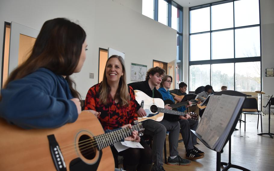 Students and a teacher in a guitar class.