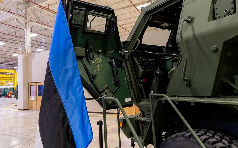 The door of a HIMARS launcher opened with an Estonian flag draped near it.