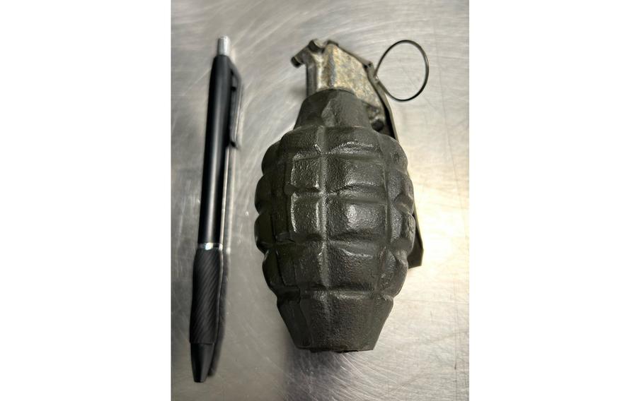 An inert grenade next to a pen