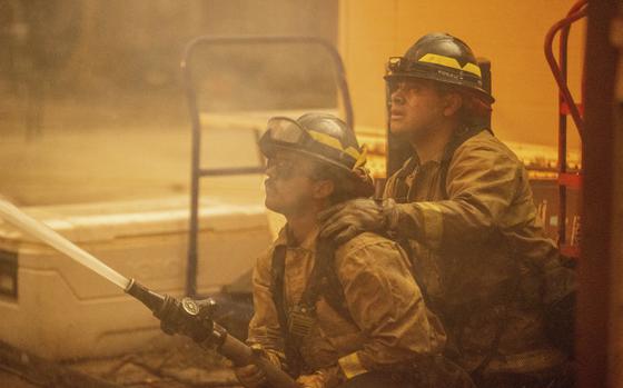 Firefighters team up to battle the Eaton Fire Wednesday, Jan. 8, 2025 in Altadena, Calif. (AP Photo/Ethan Swope)