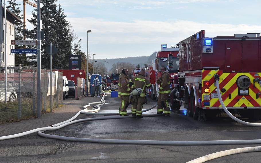 Firefighters are standing outside of a fire truck.