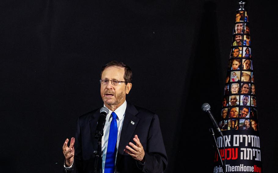 Israel’s President Isaac Herzog speaks during a ceremony to light the candles on the Hanukkiah, a nine-branched menorah candelabrum used in the Jewish holiday of Hanukkah, during a gathering with the families of hostages held by Palestinian militants since the Oct. 7 attack in Tel Aviv, on Dec. 14, 2023.