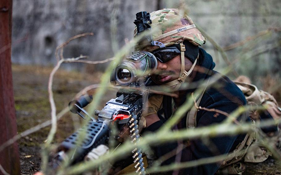 A soldier looks through the scope of his rifle.