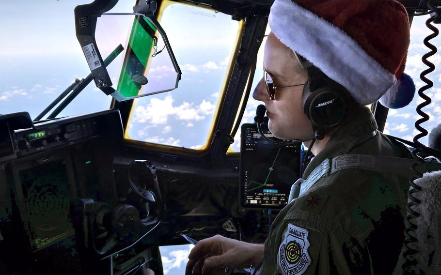 A pilot wears a Santa hat in the cockpit of a C-130J Super Hercules.