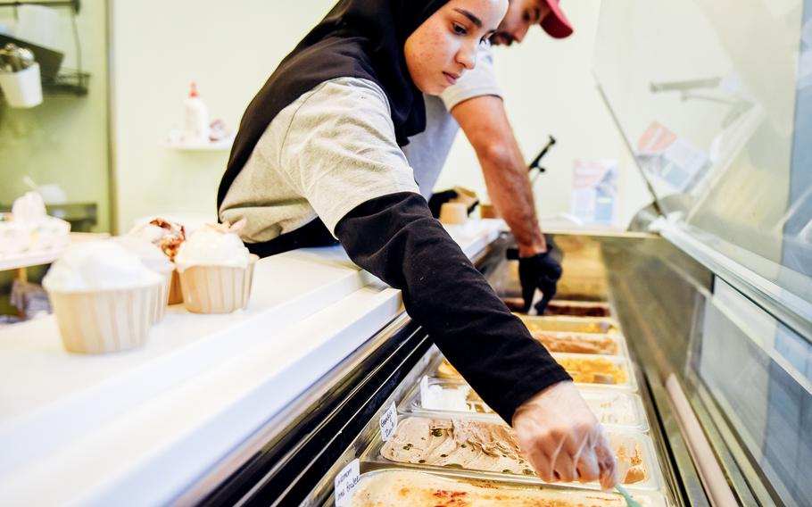 Workers at an ice cream shop in Manama, Bahrain scoop a customers order.