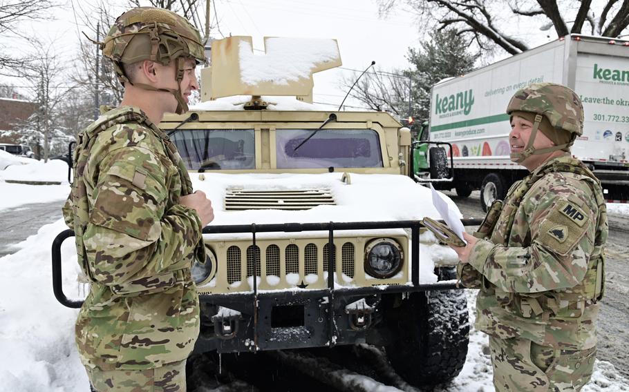 National Guard soldiers talk in the snow