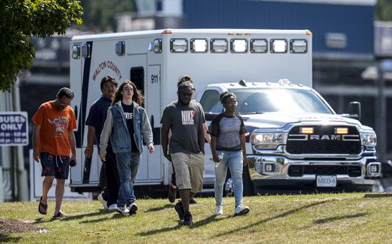 Students and parents walk off campus at Apalachee High School, Wednesday, Sept. 4, 2024, in Winder, Ga. A shooting at the Georgia high school Wednesday caused an unknown number of injuries and a suspect was arrested in a chaotic scene.