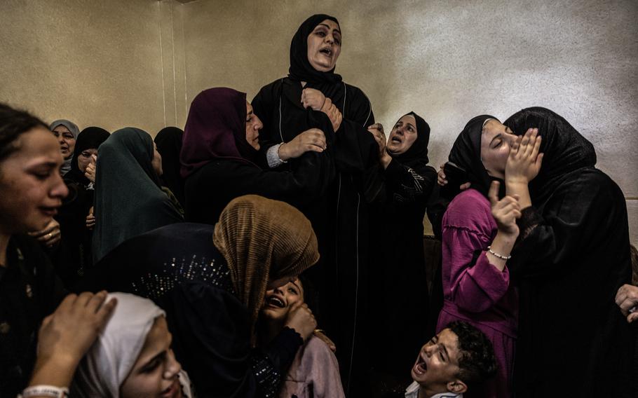 Family members gather to mourn around the body of 13-year-old Bana Laboum in the West Bank village of Qaryut on Saturday. Laboum's father and the Palestinian Health Ministry said she was shot and killed by Israeli forces on Friday. The military acknowledged opening fire and said the incident was “under review.”