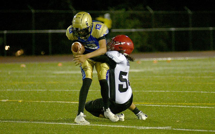 Kaiserslautern defender Julian Murdock sacks Warriors quarterback Ben Cashen during a game on Sept. 22, 2023, at Wiesbaden High School in Wiesbaden, Germany.