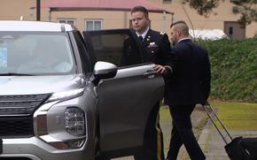 A man opens the door to an SUV to get in.