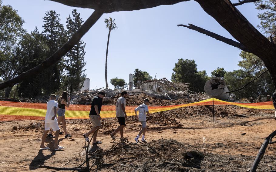 Israelis walk past a building destroyed by Iran missile attacks.