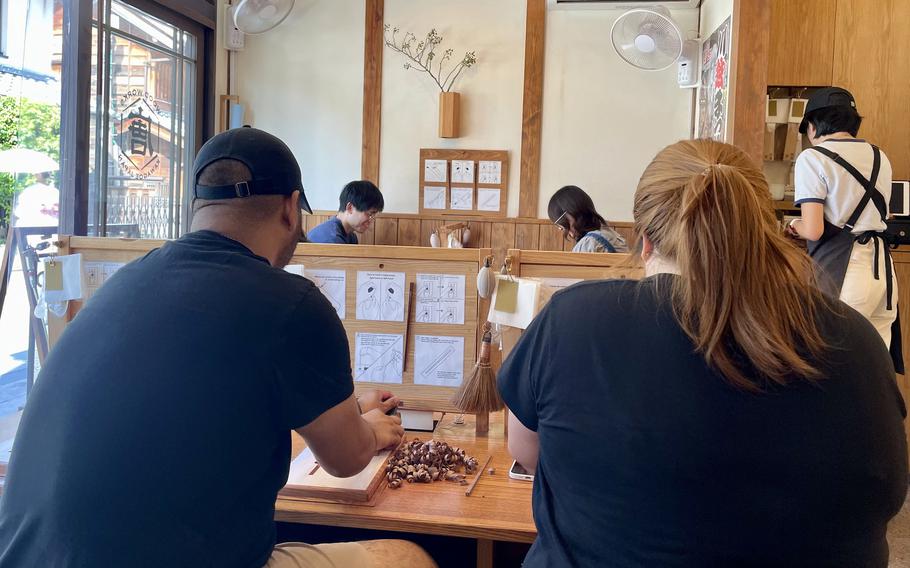 Visitors to Wood Works Kawagoe make their own chopsticks at the shop in Kawagoe, Japan.