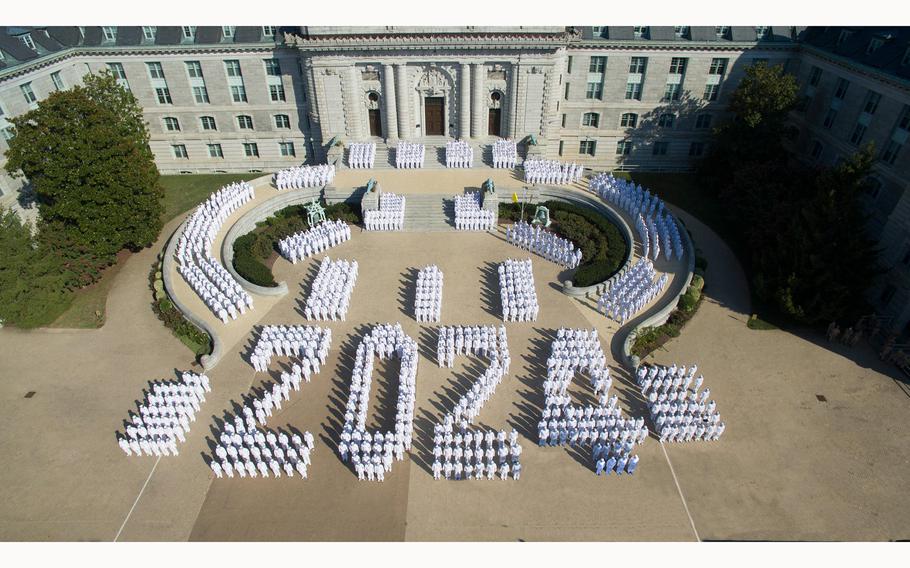 Members of the U.S. Naval Academy’s class of 2024 stand in a formation.