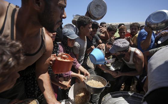 Displaced Palestinians gather for food distribution in Deir al Balah in central Gaza on Aug. 23, 2024.