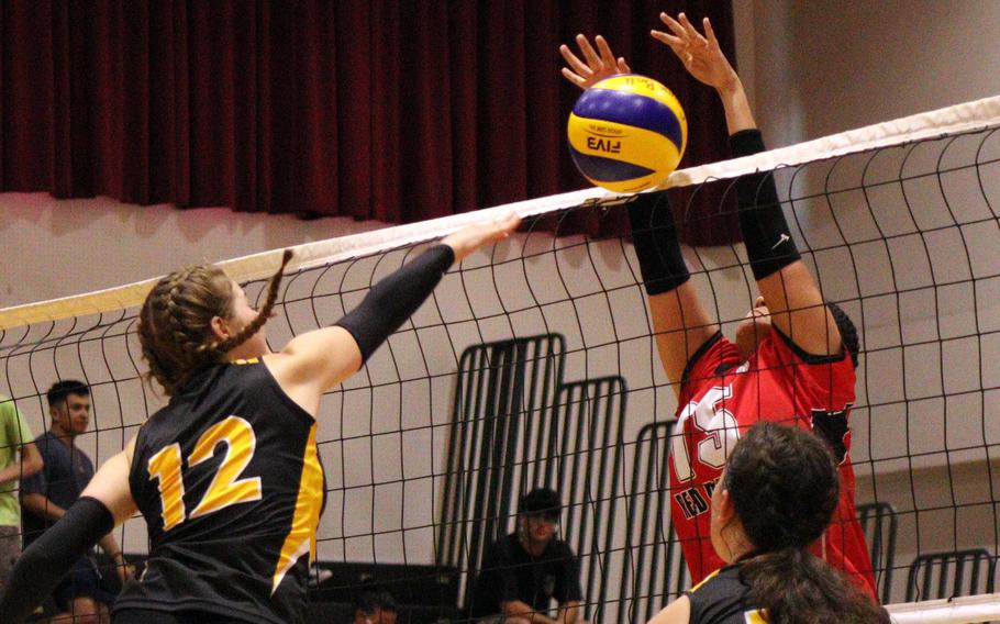 American School In Japan's Lily Stone-Borgeois has her shot blocked by Nile C. Kinnick's Leona Turner during Tuesday's Kanto Plain volleyball match. The Mustangs won in two sets.