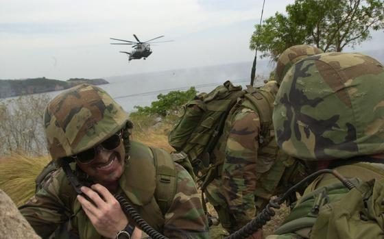 Manila Bay, Philippines, May 7, 2001: Capt. Aaron Keenan grimaces while getting blasted by rotor wash from a CH-53 helicopter, as a second helicopter approaches to land and offload U.S. Marines. 
Keenan, an F-18 pilot who was acting as a forward air controller during an amphibious assault at Ternate beach at the southern end of Manila Bay, is part of the 3rd Batallion, 7th Marines from  Twentynine Palms, Calif. The unit is deployed to Camp Schwaab, Okinawa, and is participating in Balikatan 2001 in the Philippines. 

META TAGS: USMC; U.S. Marine Corps; 3rd Batallion, 7th Marines; 