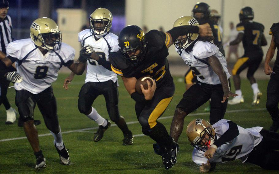 Kadena fullback Flint Barton tries to elude a gaggle of Humphreys defendes, Von Tucker (8), Scott Herber (19) and Matthew Nubin (2).