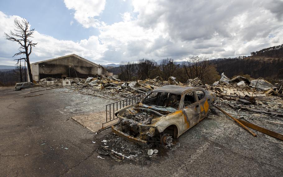 A charred car and the remains of the Swiss Chalet Hotel are pictured after being destroyed by the South Fork Fire in the mountain village of Ruidoso, N.M., Saturday, June 22, 2024.  