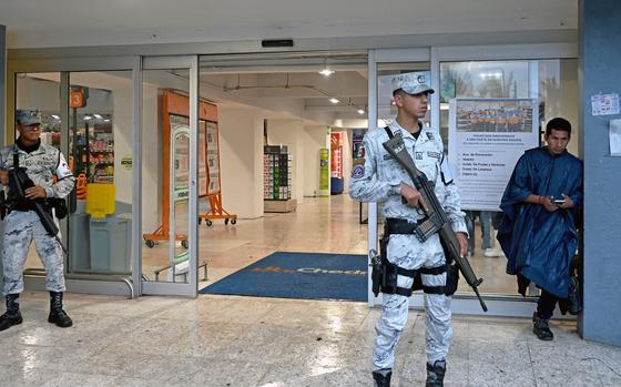 Members of the National Guard protect shops from potential looters after Hurricane John made landfall in San Marcos, Guerrero State, Mexico, on Sept. 24, 2024. Two people died in Mexico as a result of John, which made landfall in the Pacific as a category 3 hurricane on September 23 at night but dispersed on Tuesday, while the Mexican Caribbean was declared on alert for storm Helene. (Francisco Robles/AFP/Getty Images/TNS)