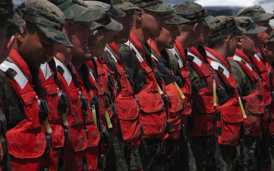 Sunburned Navy SEAL candidates stand at attention