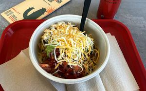 A spicy chicken burrito bowl and a soda at Burrito Bros in Aviano, Italy. Besides burrito bowls, the restaurant serves tacos, quesadillas and burritos.