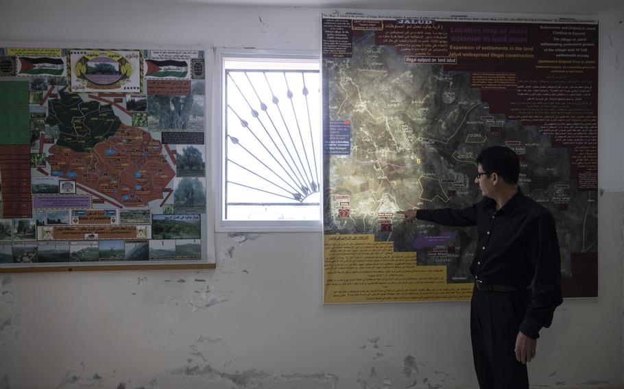 Rae Haj Mohammad points to one of two maps that show the expansion of Israeli settlements in the West Bank.