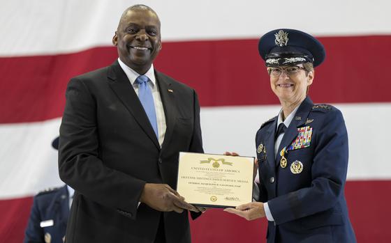 Secretary of Defense Lloyd J. Austin awards Air Force Gen. Jacqueline Van Ovost the Defense Distinguished Service Medal.