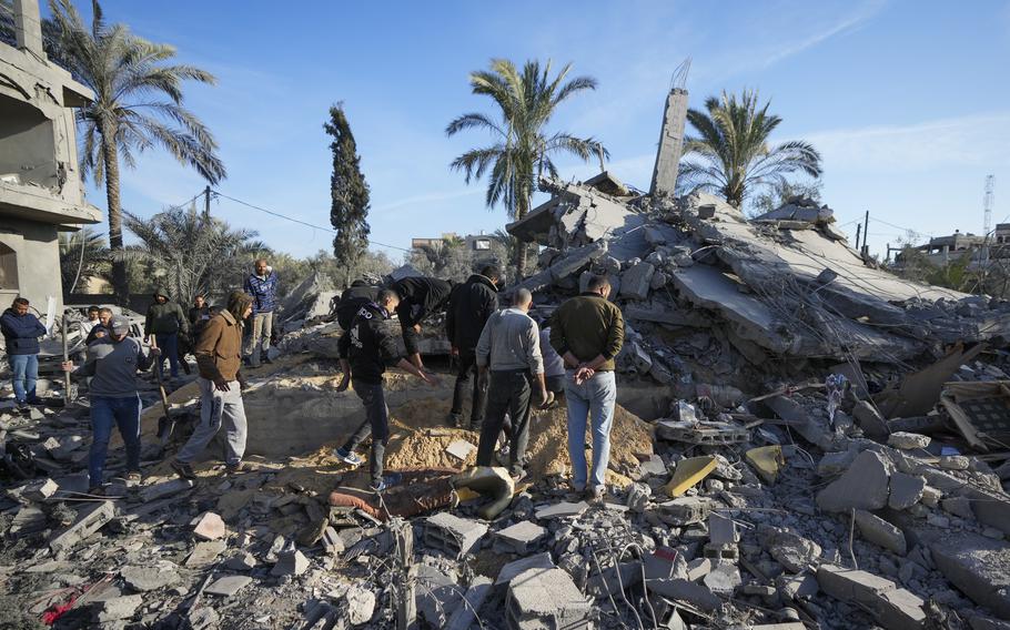 Palestinians look at home destroyed in Deir al-Balah.