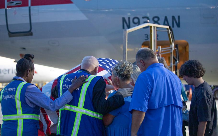 Family members of U.S. Army Pfc. Mose E. Vance are led in prayer by airport chaplains during a dignified transfer at Charlotte International Airport in Charlotte, N.C., on July 31, 2024. 