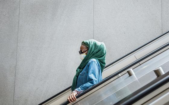 A masked commuter heads into the Metro in Washington on May 25. MUST CREDIT: Rosem Morton for The Washington Post