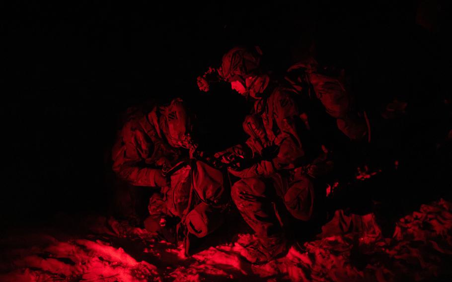 Soldiers bathed in red light.